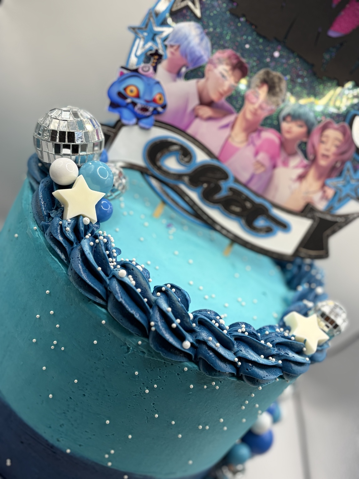 Blue K-pop character cake with stars and disco balls