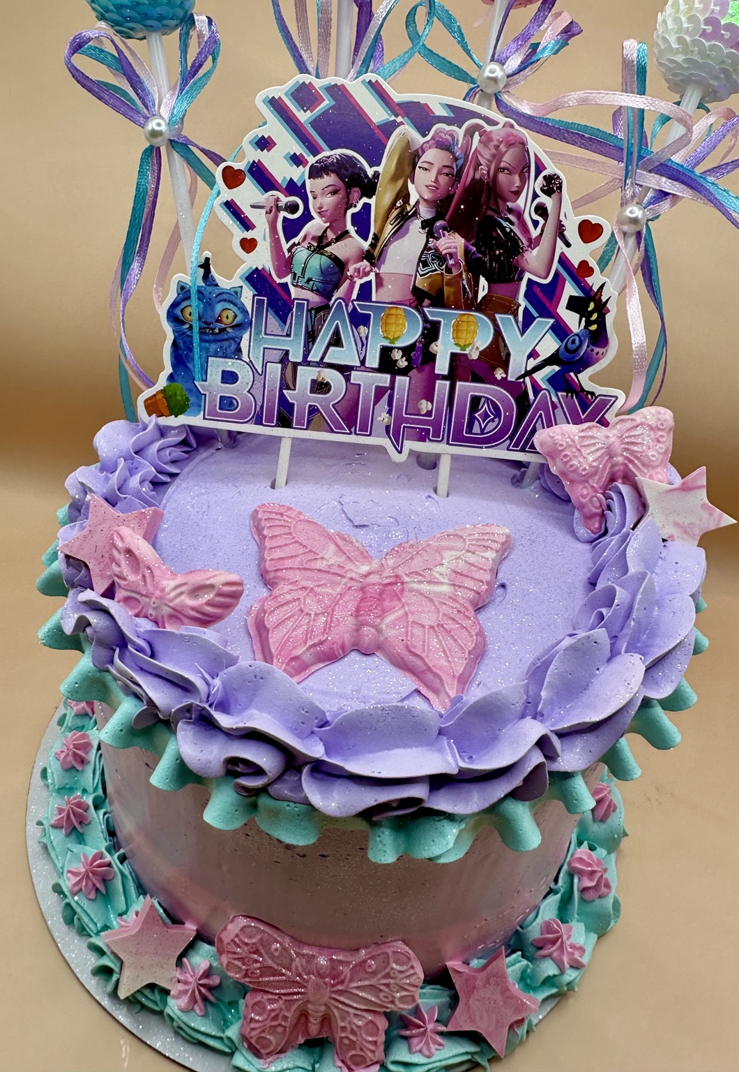Purple and teal K-pop birthday cake with butterflies